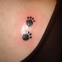 tatuaje en la espalda de dos huellas de perro