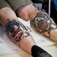 Two dogs on boths legs coloured tattoo