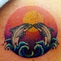 Tattoo with dolphins kiss in sunset