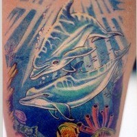 Tatuaje en color dos delfines en el fondo del mar
