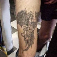 tatuaje en tinta negra de dragón volando