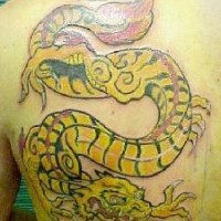 Le tatouage de dragon jaune rayé
