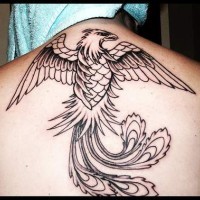 el tatuaje lineado grande de la ave fenix hecho con tinta negra en la espalda