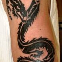 Tatuaje negro en mano de un dragón