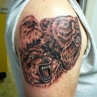 Le tatouage brutale avec un ours, un aigle et un loup sur l'épaule