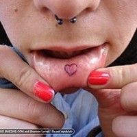simbolo cuore sul interno di labra tatuaggio