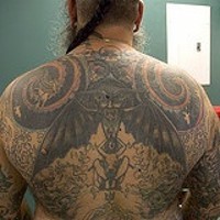 Occult themed tattoo with wings and spirals