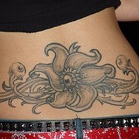 Le tatouage de fleur avec un œil sur le bas du dos
