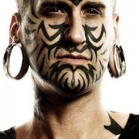 Impressionante disegno nero tatuato sul viso