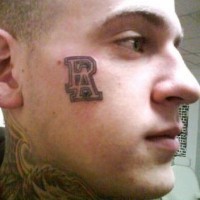 Tattoo von zwei Lettern  auf dem Gesicht