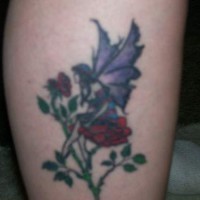 Fairy on red rose tattoo on leg