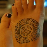 Ornamento in forma rotonda tatuato sul piede