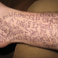 Tattoo mit vielen verschiedenen Wörtern in der Knöchelgegend