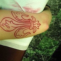 fleur de lis inchiostro rosso tatuaggio