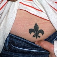 Tatuaje flor de lis en bajo espalda