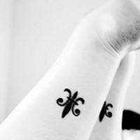 Le tatouage de fleur de lyse sur les deux jambes
