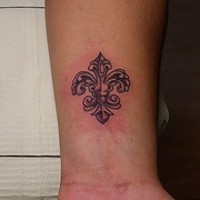Fleur de lis black ink wrist tattoo
