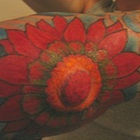 Tatuaje en mano y codo de una flor roja
