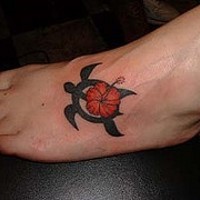 fiore rosso in tribale tartaruga tatuaggio sul piede