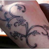 fiore nero traceri tatuaggio sul piede