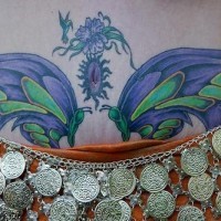 Tatuaje en vientre con dos aves en color azul y verde y una mariposa