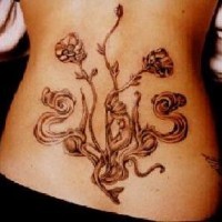 Tatuaje en bajo espalda flores con tallos color negra