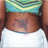 Tatuaje de flor en bajo espalda