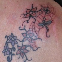 Flower shoulder tattoo, many, little flowers in net, spider, dragon-fly