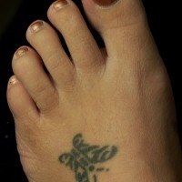 Little black sign-butterfly foot tattoo