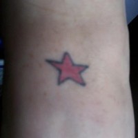 Petite étoile rouge tracé en noir  tatouage sur le pied