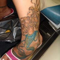 Bellissima Sirena con i capelli lunghi tatuata sulla gamba