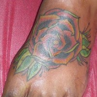 Tatuaje en el pie, flor grande rojo con hojas verdes