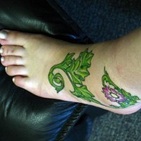 Tattoo von grüner Pflanze mit Blume auf dem Fuß
