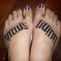 Scritta nera tatuata sui piedi della donna