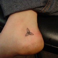 Un signe à trois branches comme une étoile tatouage sur le pied