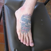 Tattoo von bösem Totenkopf mit Zähnen auf dem Fuß