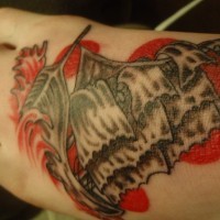 Tattoo vom Segelschiff in roten Wellen auf dem Fuß