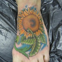 Tattoo von feiner Sonnenblume mit saftigen Blättern auf dem Fuß