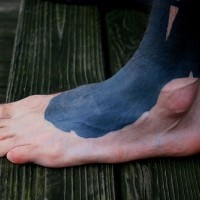 Tattoo von umgekippter Tinte  auf dem Fuß