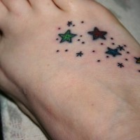 Tattoo von vielen farbigen Sternen und  Pünktchen auf dem Fuß
