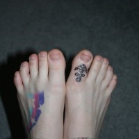 Le tatouage sur le gros orteil d'un ancre avec des étoiles