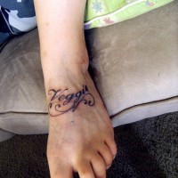 Tatuaje en el pie, la inscripción veggu, letra cursiva