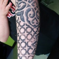 Parti-coloured pattern, orbed crosses , curls forearm tattoo