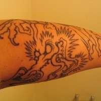 Dragon méchant avec les griffes aigus le tatouage avant-bras