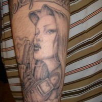 Tatuaje en el antebrazo,  chica guapa que sostiene un arma, inscripción