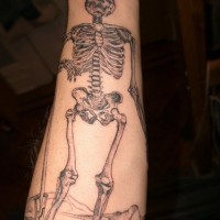 Tall, morose skull on the road forearm tattoo