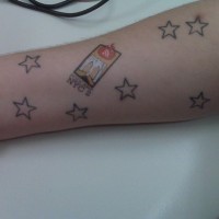 Tattoo von farbigem Aufkleber und sieben Sternen am Unterarm