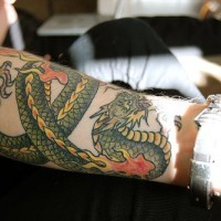 Tatuaje en el antebrazo, dragon verde largo envuelto en la mano