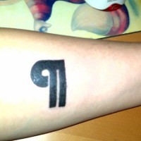 Un segno grosso piccolo tatuato sul braccio