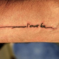 Uneven seam with french inscription  forearm tattoo
